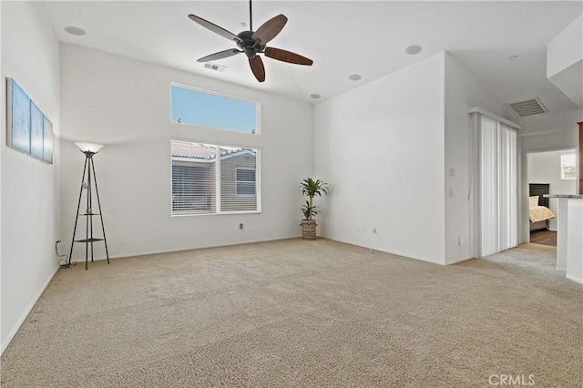 spare room featuring visible vents, carpet, and a ceiling fan