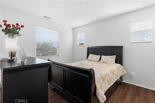 bedroom with dark wood finished floors, baseboards, and visible vents