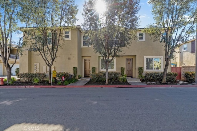 view of property with stucco siding and fence