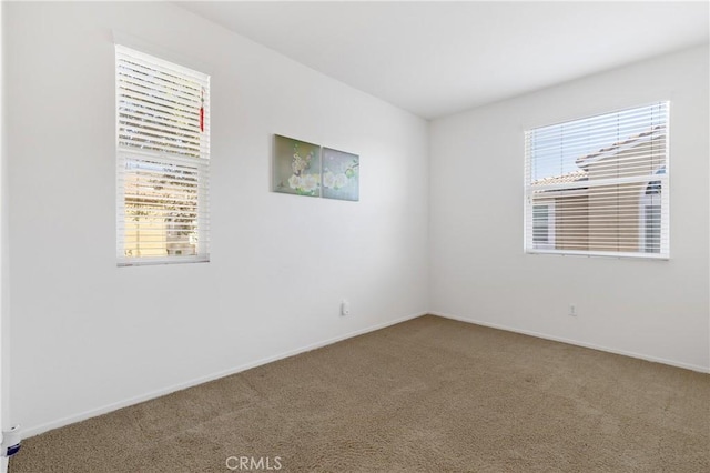 unfurnished room featuring baseboards and carpet