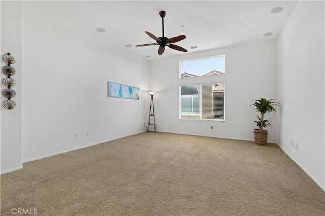 carpeted spare room with visible vents and ceiling fan