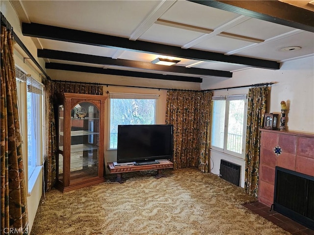 unfurnished living room with heating unit, carpet, beam ceiling, and a tile fireplace