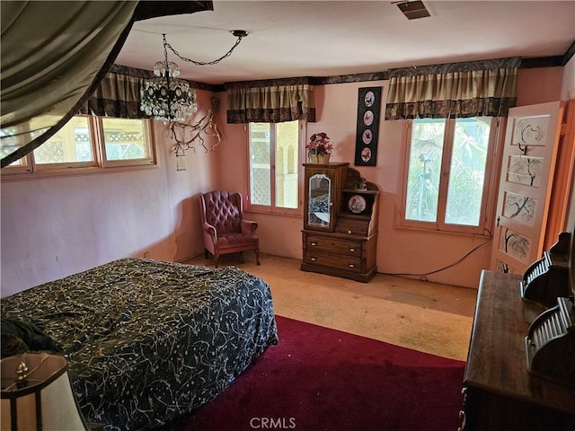 carpeted bedroom with a chandelier and visible vents