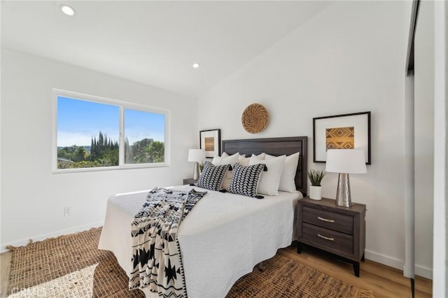 bedroom featuring baseboards, vaulted ceiling, wood finished floors, and recessed lighting