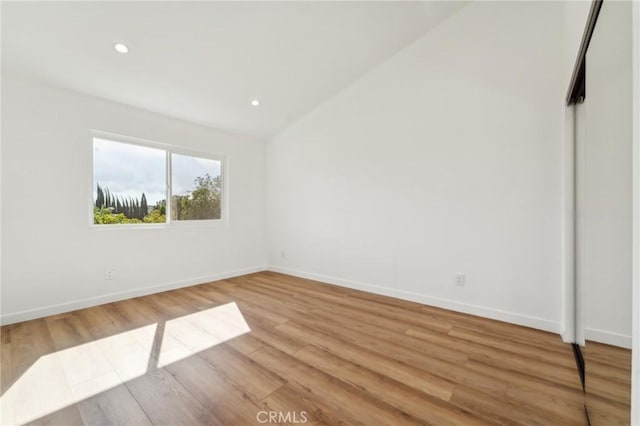 unfurnished bedroom featuring vaulted ceiling, recessed lighting, light wood-type flooring, and baseboards