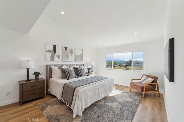 bedroom featuring lofted ceiling, light wood-style floors, baseboards, and recessed lighting