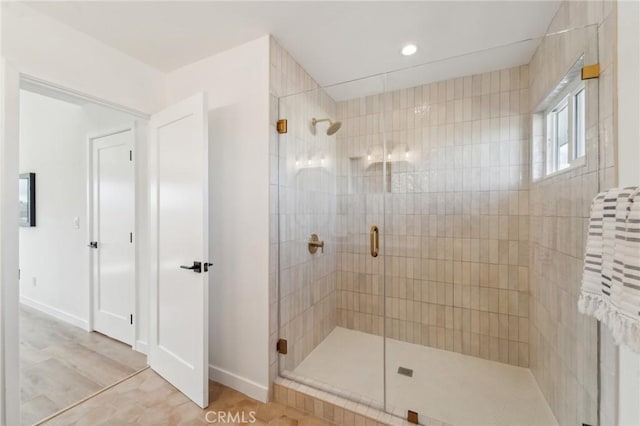 bathroom with a stall shower and baseboards