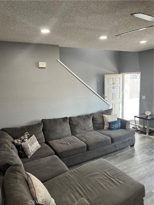 living room with a textured ceiling, wood finished floors, and recessed lighting