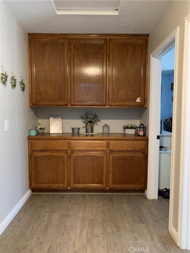 bar featuring light wood-style flooring and baseboards