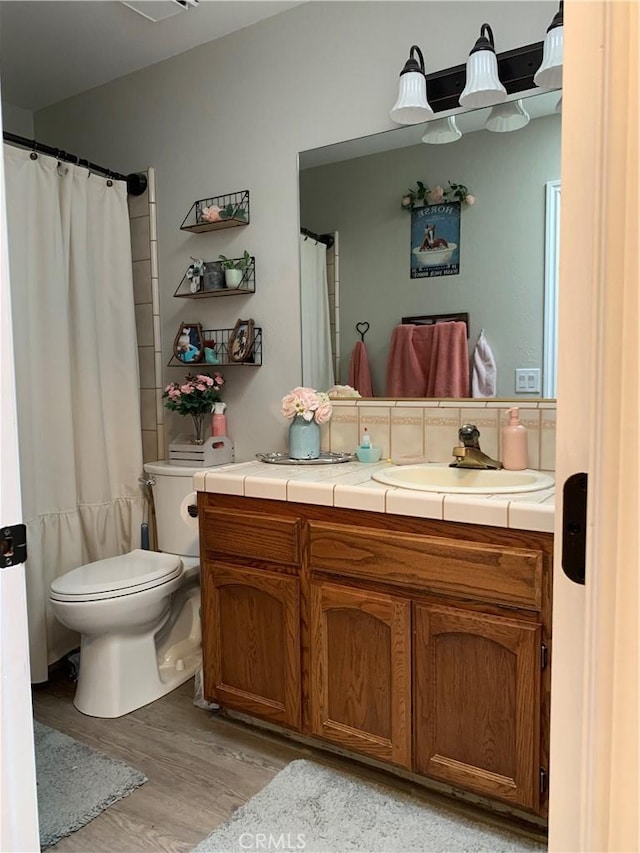 full bath with vanity, wood finished floors, toilet, and decorative backsplash