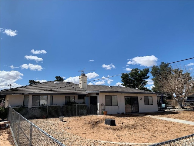 single story home featuring a chimney and fence