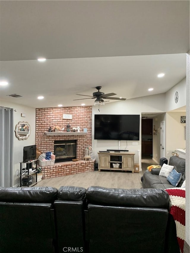 living area featuring a fireplace, wood finished floors, a ceiling fan, and recessed lighting