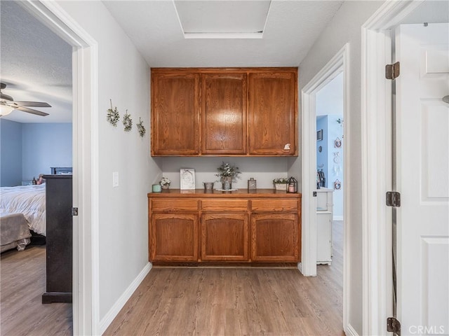 20312 Eyota Rd, Apple Valley, CA 92308 - kitchen featuring baseboards, brown cabinets, and light wood-style floors