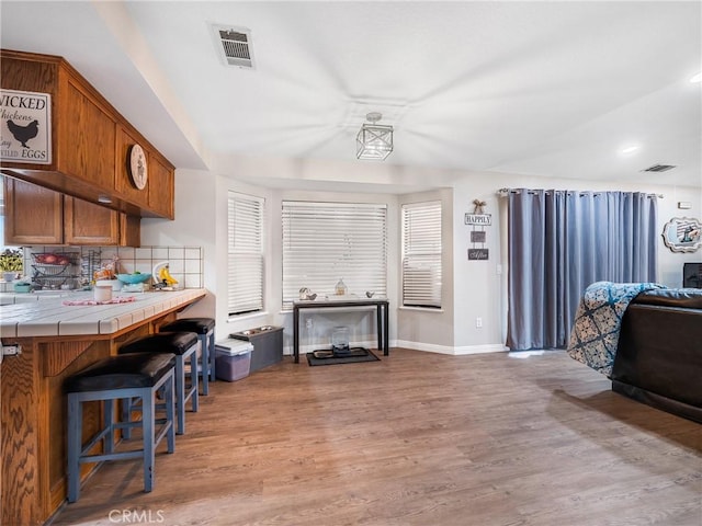 20312 Eyota Rd, Apple Valley, CA 92308 - kitchen with tile countertops, visible vents, light wood finished floors, and brown cabinets