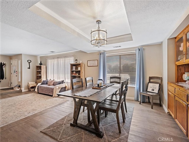 20312 Eyota Rd, Apple Valley, CA 92308 - dining area featuring a notable chandelier, visible vents, light wood-style flooring, and a raised ceiling