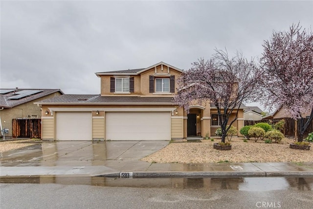 view of front facade featuring fence, driveway, and stucco siding