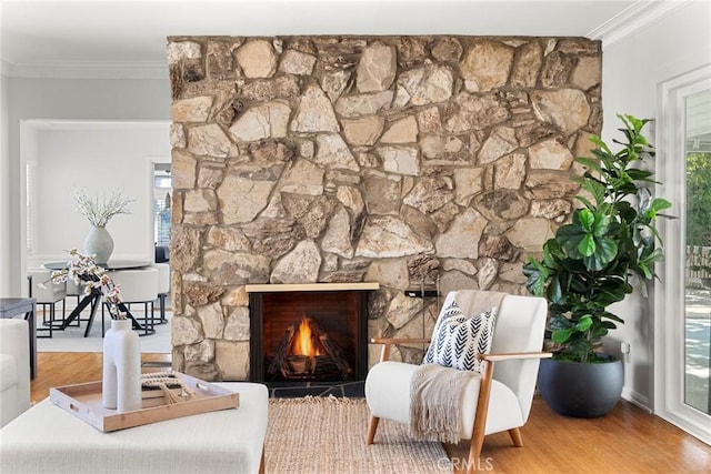 sitting room featuring a wealth of natural light, a fireplace, wood finished floors, and ornamental molding