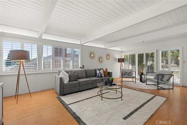 living area featuring beam ceiling and wood finished floors