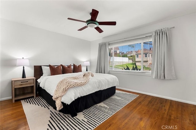 bedroom with ceiling fan, baseboards, and wood finished floors