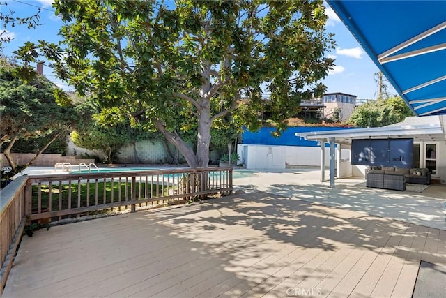 deck with an outdoor living space, a fenced in pool, and a fenced backyard