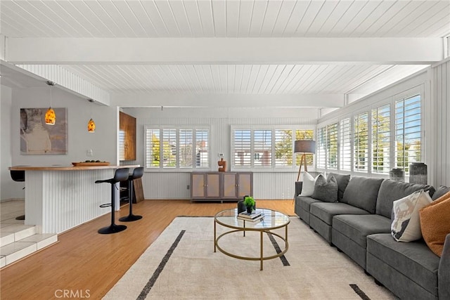 living room featuring beamed ceiling, a dry bar, wood ceiling, and wood finished floors