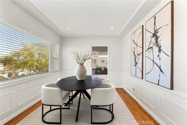 dining room with a decorative wall, recessed lighting, and wood finished floors