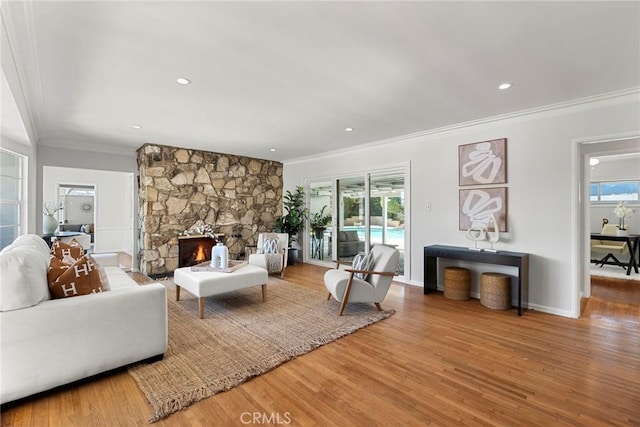 living area featuring a wealth of natural light, wood finished floors, and a fireplace