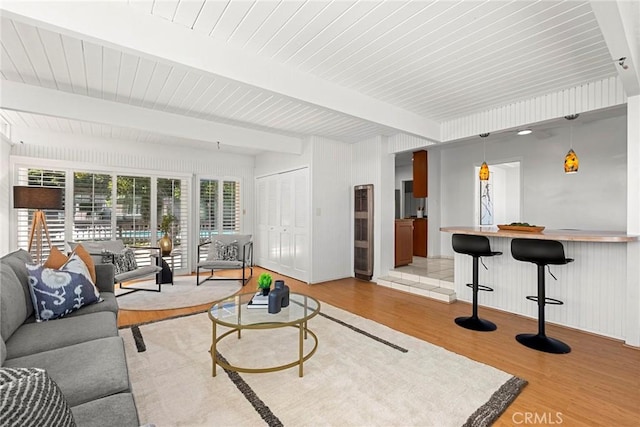 living room featuring beamed ceiling and wood finished floors