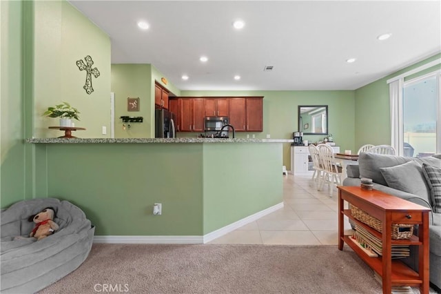 kitchen featuring recessed lighting, appliances with stainless steel finishes, open floor plan, light tile patterned flooring, and light carpet