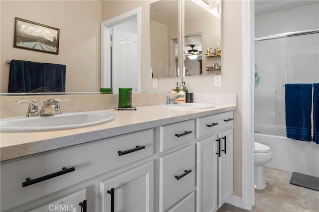 full bathroom with double vanity, toilet, and enclosed tub / shower combo