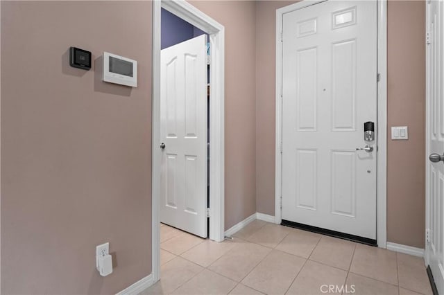 foyer with baseboards and light tile patterned floors