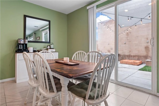 dining space featuring light tile patterned flooring and baseboards