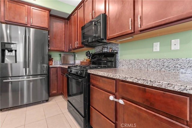 kitchen featuring light stone countertops, black appliances, and light tile patterned floors