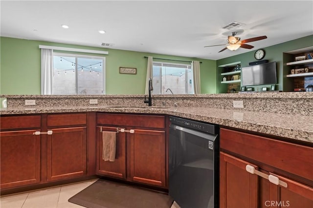 kitchen featuring light tile patterned floors, light stone counters, a sink, visible vents, and dishwasher