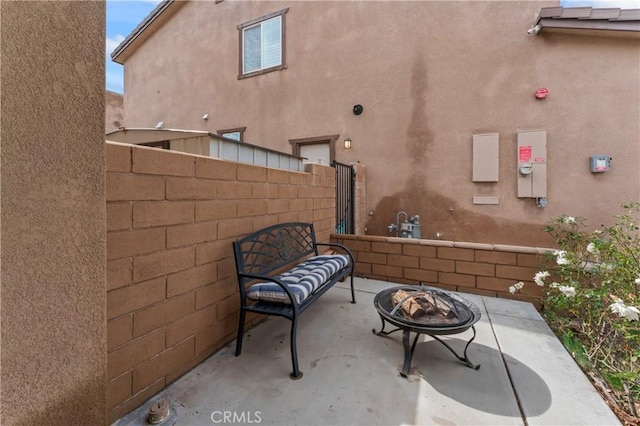 view of patio with an outdoor fire pit and fence