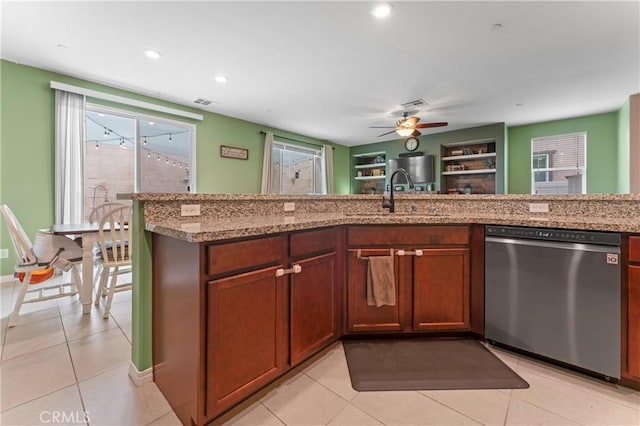 kitchen featuring light tile patterned flooring, dishwasher, a sink, and light stone countertops