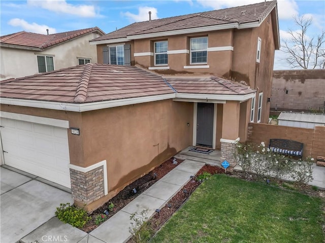 view of front of home featuring a garage, a tiled roof, and stucco siding