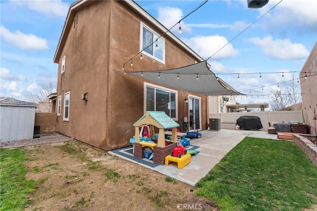 back of house with a patio, a fenced backyard, cooling unit, a yard, and stucco siding