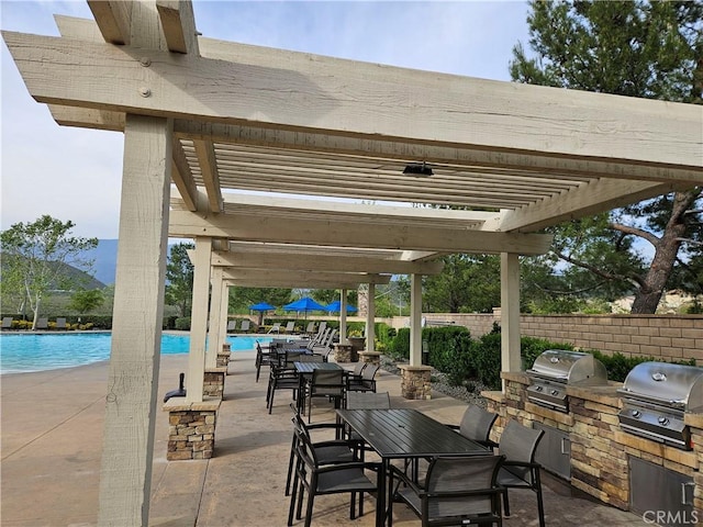 view of patio featuring area for grilling, a grill, a community pool, and fence