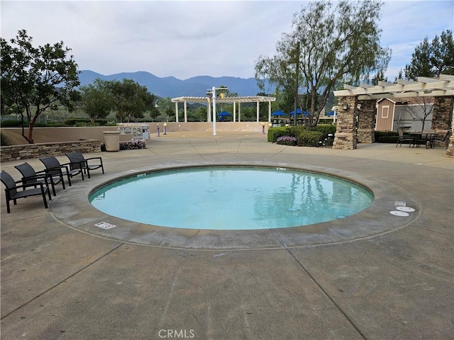 view of pool featuring a pergola, a mountain view, a patio area, and a swimming pool