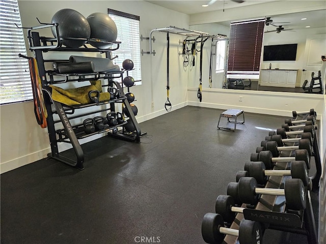 workout area featuring a ceiling fan and baseboards