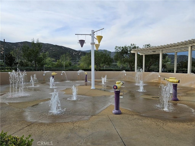view of community with a mountain view and a pergola