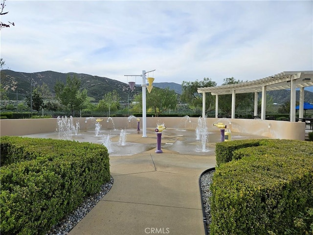 view of property's community with a mountain view and a pergola