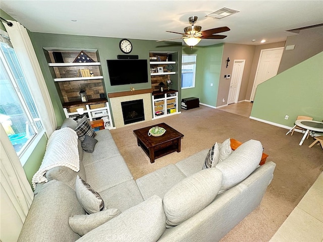 carpeted living area featuring ceiling fan, baseboards, built in shelves, recessed lighting, and a fireplace