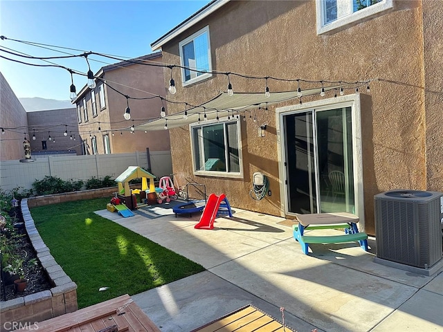 back of property with cooling unit, stucco siding, and a patio