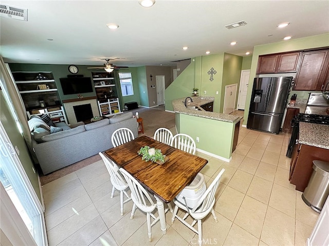 dining space featuring a ceiling fan, light tile patterned floors, a fireplace, recessed lighting, and built in features