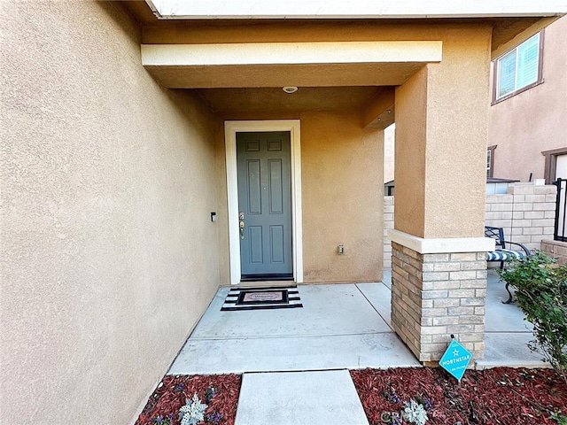 doorway to property featuring stucco siding