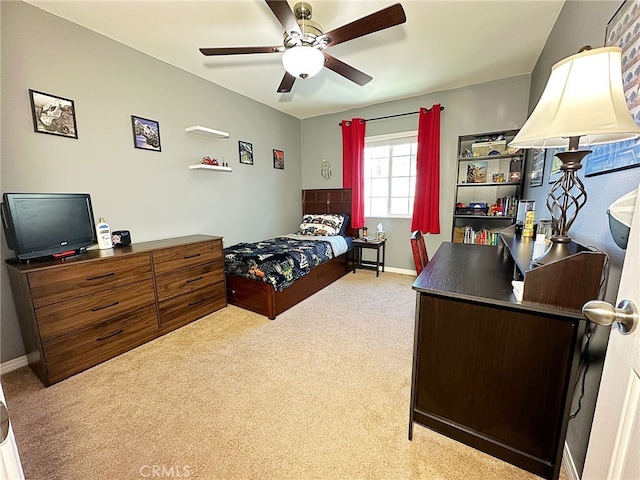 bedroom with light carpet, baseboards, a desk, and ceiling fan