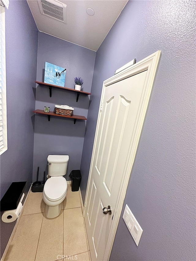 bathroom featuring tile patterned floors, toilet, and baseboards