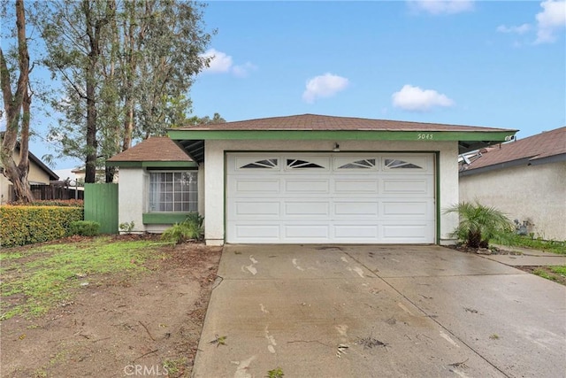 view of front of home featuring a garage, driveway, and stucco siding